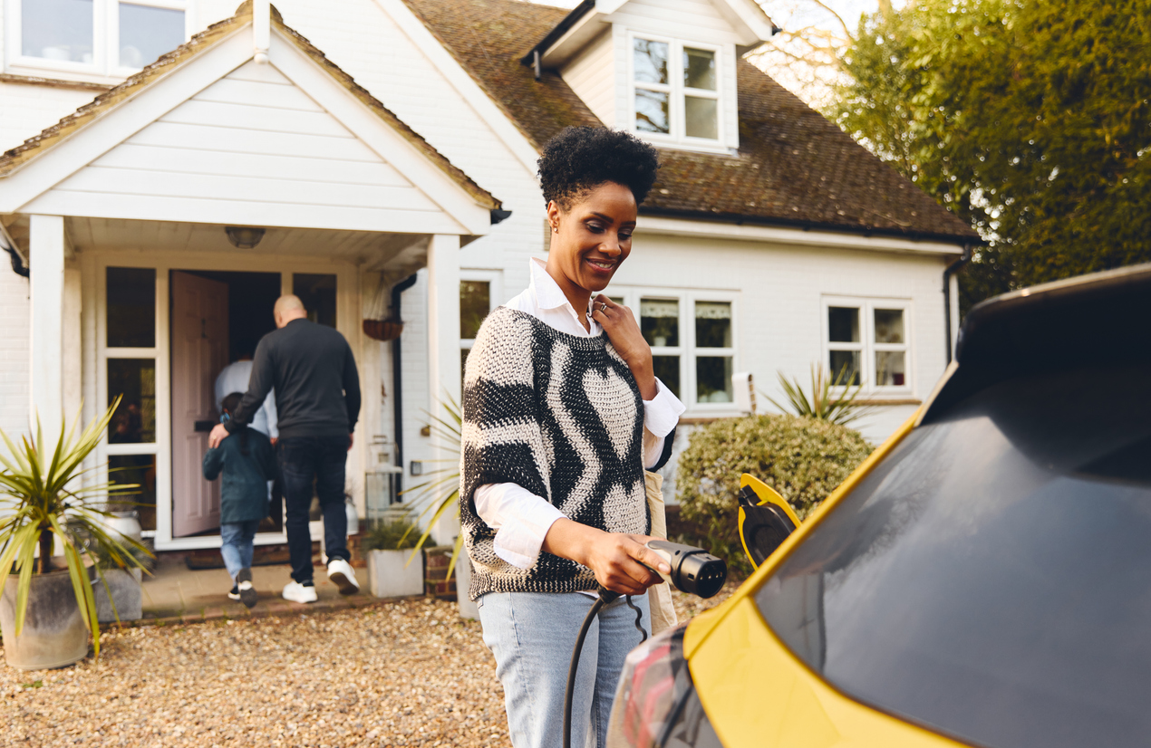 A woman plugging her EV into a level 2 EV charger outside of her Cincinnati home.